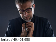 Priest praying hands with rosary beads male. Стоковое фото, агентство Ingram Publishing / Фотобанк Лори