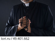 Priest praying hands with rosary beads male. Стоковое фото, агентство Ingram Publishing / Фотобанк Лори