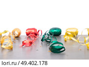 Carnaval festive curling paper decorations on dark wooden background border over white. Carnaval decorations on dark wooden background. Стоковое фото, агентство Ingram Publishing / Фотобанк Лори