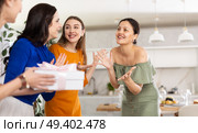 Three women have arrived for birthday celebration and presenting gift to birthday woman. Стоковое фото, фотограф Яков Филимонов / Фотобанк Лори