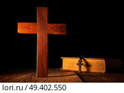 Christian wood cross on black wooden made with Bible and rosary beads. Стоковое фото, агентство Ingram Publishing / Фотобанк Лори