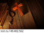 Christian cross on wood bible and rosary beads over wooden vintage background. Стоковое фото, агентство Ingram Publishing / Фотобанк Лори