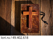 Christian cross on wood bible and rosary beads over wooden vintage background. Стоковое фото, агентство Ingram Publishing / Фотобанк Лори