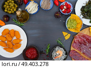 Table with spanish tapas food - anchovies with peppers padron, jamon, croquetes, guacamole and olives, frame with copy space. Table with spanish tapas. Стоковое фото, агентство Ingram Publishing / Фотобанк Лори