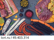 spanish tapas with salami, chorizo, lomo, jamon with red hot salsa sause and olives, picnic table, top view, retro toned. Picnic table with spanish sausage tapas. Стоковое фото, агентство Ingram Publishing / Фотобанк Лори