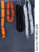 Cured meat and sausages hanging a rack at market, vertical shot. Cured meat and sausages. Стоковое фото, агентство Ingram Publishing / Фотобанк Лори