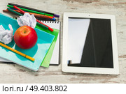 Apple with school supplies and tablet on white wooden table. Apple with school supplies. Стоковое фото, агентство Ingram Publishing / Фотобанк Лори