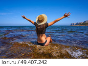 Bikini girl in summer Mediterranean beach having fun sit open arms excited. Стоковое фото, агентство Ingram Publishing / Фотобанк Лори