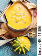 Autumn pumpkin soup in a metal saucepan.Autumn food. Pumpkin soup on a wooden table. Стоковое фото, агентство Ingram Publishing / Фотобанк Лори