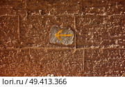 Yellow arrow sign of Camino de Santiago way of Saint James pilgrims in adobe wall. Стоковое фото, агентство Ingram Publishing / Фотобанк Лори