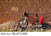Yellow arrow sign and bicycle of Camino de Santiago way of Saint James pilgrims. Стоковое фото, агентство Ingram Publishing / Фотобанк Лори