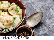 Russian meat dumplings pelmeni on rustic background.Russian pelmeni. Ukrainian pelmeni on plate. Стоковое фото, агентство Ingram Publishing / Фотобанк Лори