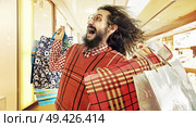 Funny image of nerdy guy during a sale madness. Стоковое фото, агентство Ingram Publishing / Фотобанк Лори
