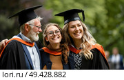 A group of individuals standing together, all donning graduation caps and gowns to celebrate their academic achievement. Стоковое AI-изображение, AI-художник Данила Большаков / Фотобанк Лори