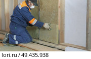 Insulation of a frame house with mineral wool. Cutting, fitting, laying insulation. Construction works. Стоковое видео, видеограф Константин Мерцалов / Фотобанк Лори
