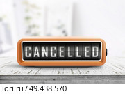 Cancelled message on a retro alarm clock in a bright room with a weathered wooden table. Стоковое фото, агентство Ingram Publishing / Фотобанк Лори