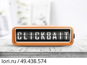 Clickbait text on a digital device in orange color in a bright room. Стоковое фото, агентство Ingram Publishing / Фотобанк Лори