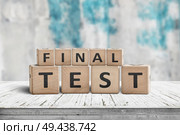 Final test spelled with letter cubes on a wooden table and a blurry blue background. Стоковое фото, агентство Ingram Publishing / Фотобанк Лори