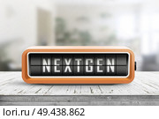 Nextgen word on an alarm device in orange color on a wooden desk in a living room. Стоковое фото, агентство Ingram Publishing / Фотобанк Лори