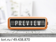 Preview sign in form of a retro alarm clock on a wooden desk in a bright room with sunlight. Стоковое фото, агентство Ingram Publishing / Фотобанк Лори