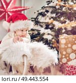 Cute little son looking at the Christmas gifts. Стоковое фото, агентство Ingram Publishing / Фотобанк Лори