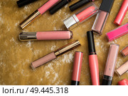 lip gloss in assortiment around golden backround. Стоковое фото, агентство Ingram Publishing / Фотобанк Лори