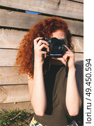 Young redhead photographer woman enjoying her passion outdoors. Стоковое фото, агентство Ingram Publishing / Фотобанк Лори
