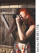 Young redhead photographer woman enjoying her passion outdoors. Стоковое фото, агентство Ingram Publishing / Фотобанк Лори
