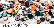 Spools of threads and buttons on wooden table.Needlework and tailoring concept. Various sewing buttons and thread. Стоковое фото, агентство Ingram Publishing / Фотобанк Лори