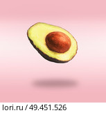 Flying half avocado with seed at pink background with shadow. Concept of food levitation. Стоковое фото, агентство Ingram Publishing / Фотобанк Лори
