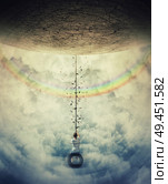 Young boy suspend on a tire swing in the clouds over the rainbow, avoiding the gravitational force. Having fun and freedom concept. Стоковое фото, агентство Ingram Publishing / Фотобанк Лори