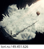 Boy in a abstract place above the clouds, looking for the right pathway to air balloon. Risky choice. Way to success symbol. Стоковое фото, агентство Ingram Publishing / Фотобанк Лори