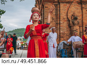 Vietnamese women in traditional red clothes dance in the towers of Nagar Cham in Asia. Nha Trang, Vietnam - December 18, 2024. Редакционное фото, фотограф Корчагина Анастасия / Фотобанк Лори