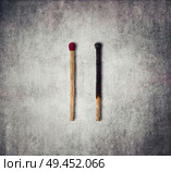 Close-up of a burnt match and a whole red match isolated on a gray background. Стоковое фото, агентство Ingram Publishing / Фотобанк Лори