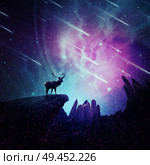 Majestic deer with long stand on the peak of a rocky hill below a wonderful night sky with falling stars and sparkles. Mystic wild scene screen saver. Стоковое фото, агентство Ingram Publishing / Фотобанк Лори