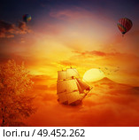 Vintage, old ship sailing lost in the sky. Adventure and journey concept. Beautiful sunset background over the clouds. Стоковое фото, агентство Ingram Publishing / Фотобанк Лори
