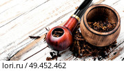 Tobacco pipe or smoking pipe on a wooden table. Smoking pipe on a wooden table. Стоковое фото, агентство Ingram Publishing / Фотобанк Лори