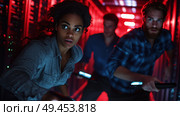 Group of people navigating a dimly lit server room with flashlights during a tense moment. Стоковое AI-изображение, AI-художник Сергей Толмачёв / Фотобанк Лори