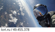 A man in a black helmet is taking a picture of the earth from a plane. Стоковое AI-изображение, AI-художник Ярославский Максим / Фотобанк Лори