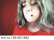 Young woman with a cross covering her mouth                               . Стоковое фото, агентство Ingram Publishing / Фотобанк Лори