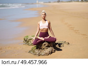 Caucasian woman practicing yoga at seashore. Young female doing lotus pose in the beach in Cadiz, Andalusia, Spain.. Caucasian blonde woman practicing yoga in the beach. Стоковое фото, агентство Ingram Publishing / Фотобанк Лори
