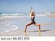Caucasian woman practicing yoga at seashore. Young female raising arms in the beach in Cadiz, Andalusia, Spain.. Caucasian blonde woman practicing yoga in the beach. Стоковое фото, агентство Ingram Publishing / Фотобанк Лори