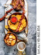 Selection of beer and snacks.Chips, fish, beer sausages on the table. Snacks for beer. Стоковое фото, агентство Ingram Publishing / Фотобанк Лори