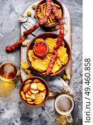 Beer and snacks.Chips, fish, beer sausages on the table. Lager beer and snacks. Стоковое фото, агентство Ingram Publishing / Фотобанк Лори