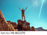 Handsome man standing on the giant rock. Стоковое фото, агентство Ingram Publishing / Фотобанк Лори
