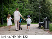 A family with three children. A mother with many children and toddlers in a summer park. Children are walking in the fresh air. Having many children and family values. Стоковое фото, фотограф Photojuli / Фотобанк Лори