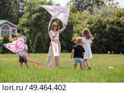 A family with three children. A mother with many children and toddlers in a summer park. Children are walking and flying a kite. Large families, family values, and leisure time with children. Стоковое фото, фотограф Photojuli / Фотобанк Лори