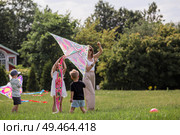 A family with three children. A mother with many children and toddlers in a summer park. Children are walking and flying a kite. Large families, family values, and leisure time with children. Стоковое фото, фотограф Photojuli / Фотобанк Лори