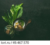 Wild garlic yogurt dip or dressing in wooden bowl on dark rustic kitchen table background with ingredients, top view with copy space. Healthy seasonal food concept. Стоковое фото, агентство Ingram Publishing / Фотобанк Лори