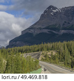 Highway with mountains in the background, Saskatchewan River Crossing, Icefields Parkway, Jasper, Alberta, Canada. Highway with mountains in the background, Saskatchewan River Crossing, Icefields Parkway, Jasper, Alberta, Canada . Стоковое фото, агентство Ingram Publishing / Фотобанк Лори